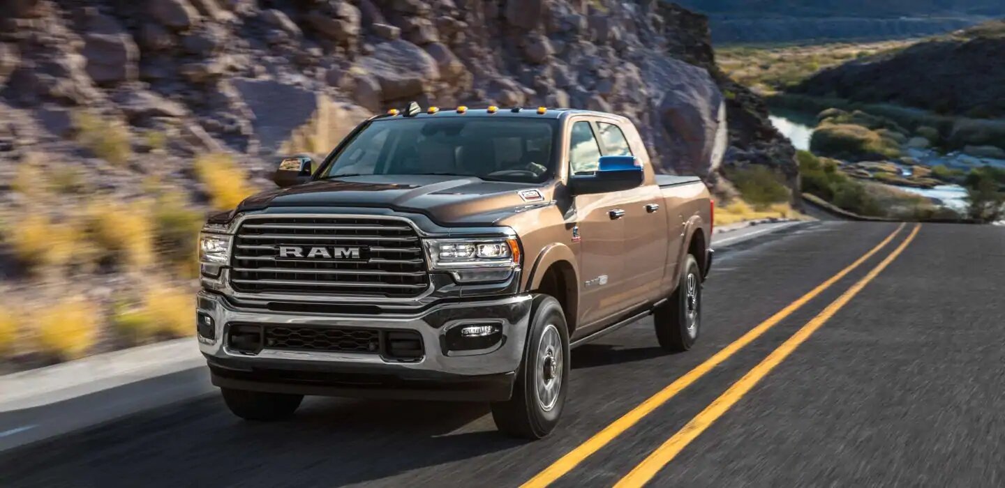 a brown 2020 ram 2500 driving through the mountain road