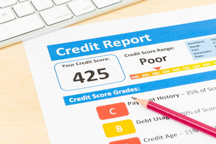Poor credit score report of 425 with pen and keyboard
