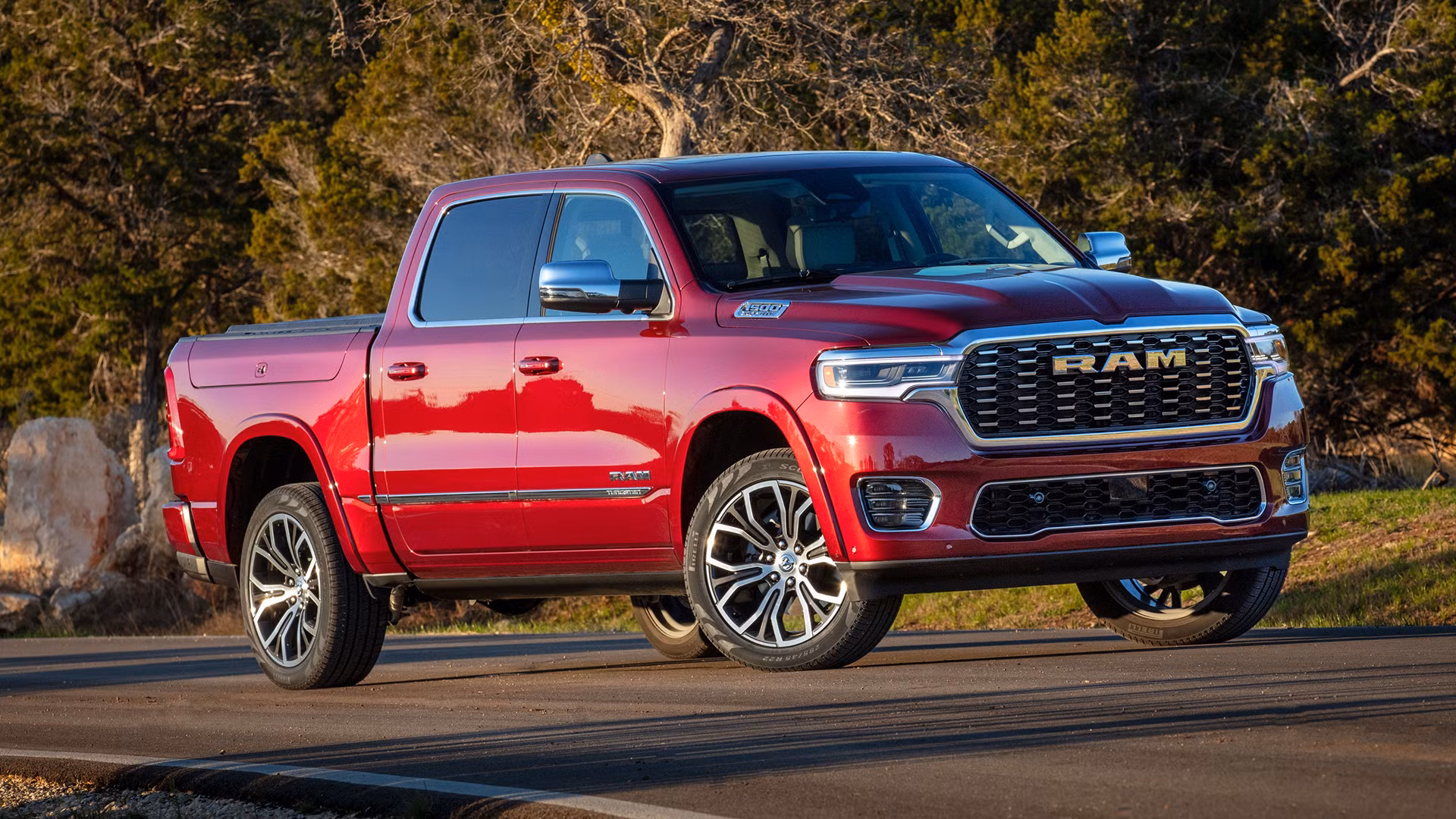 a red RAM half-ton truck parking on a mountain road with sun shining down from above