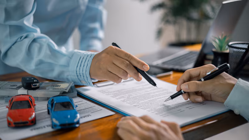 Car buyer reviewing financing documents highlighting income and debt factors lenders evaluate besides credit score.