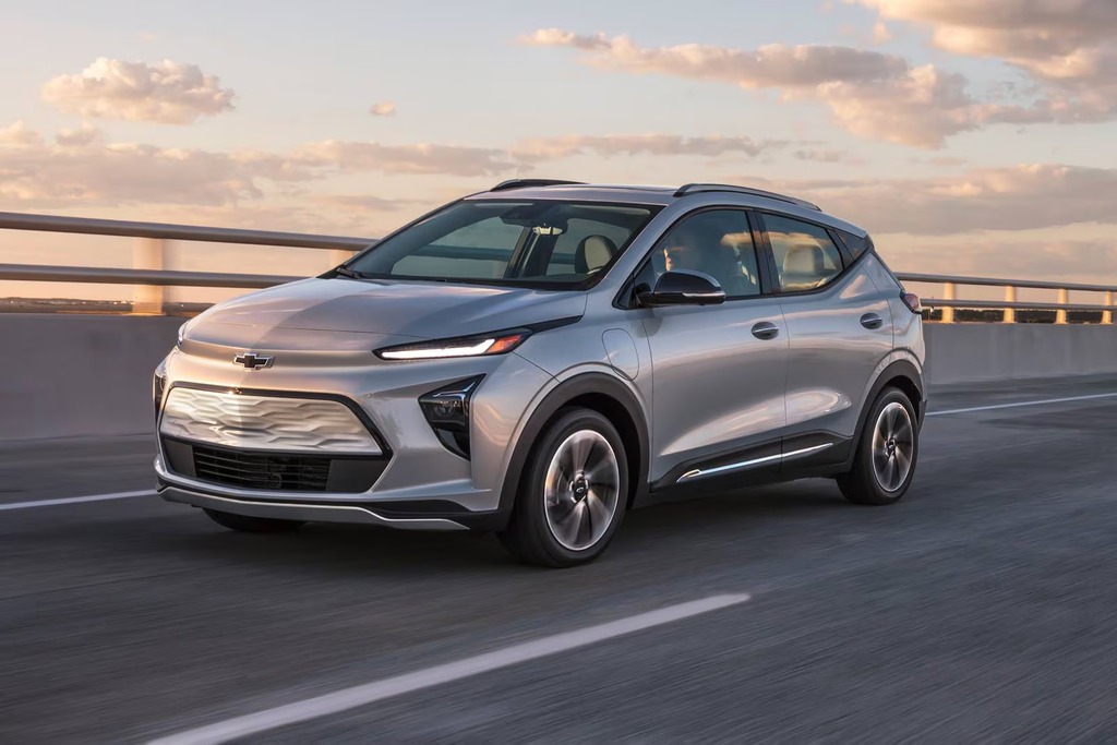 Silver 2022 Chevrolet Bolt EUV cruising on a highway during sunset.