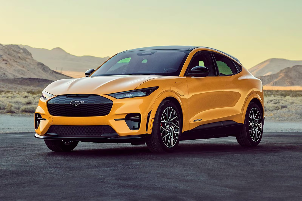 Orange 2022 Ford Mustang Mach-E parked on a desert road, showcasing its sporty EV design.
