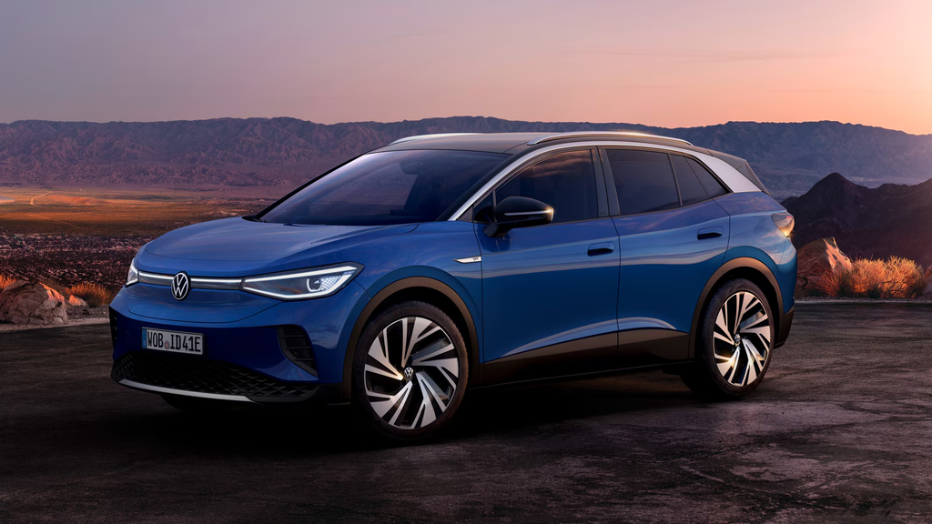 Blue 2022 Volkswagen ID.4 electric SUV parked at a scenic mountain overlook at sunset.